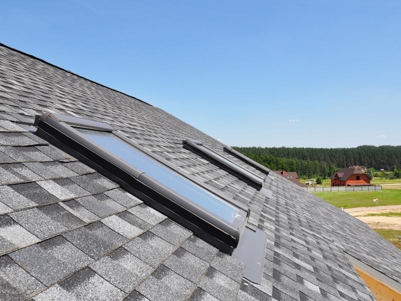 Roof-mounted skylights installed on an asphalt shingle roof to bring natural daylight into a residential home
